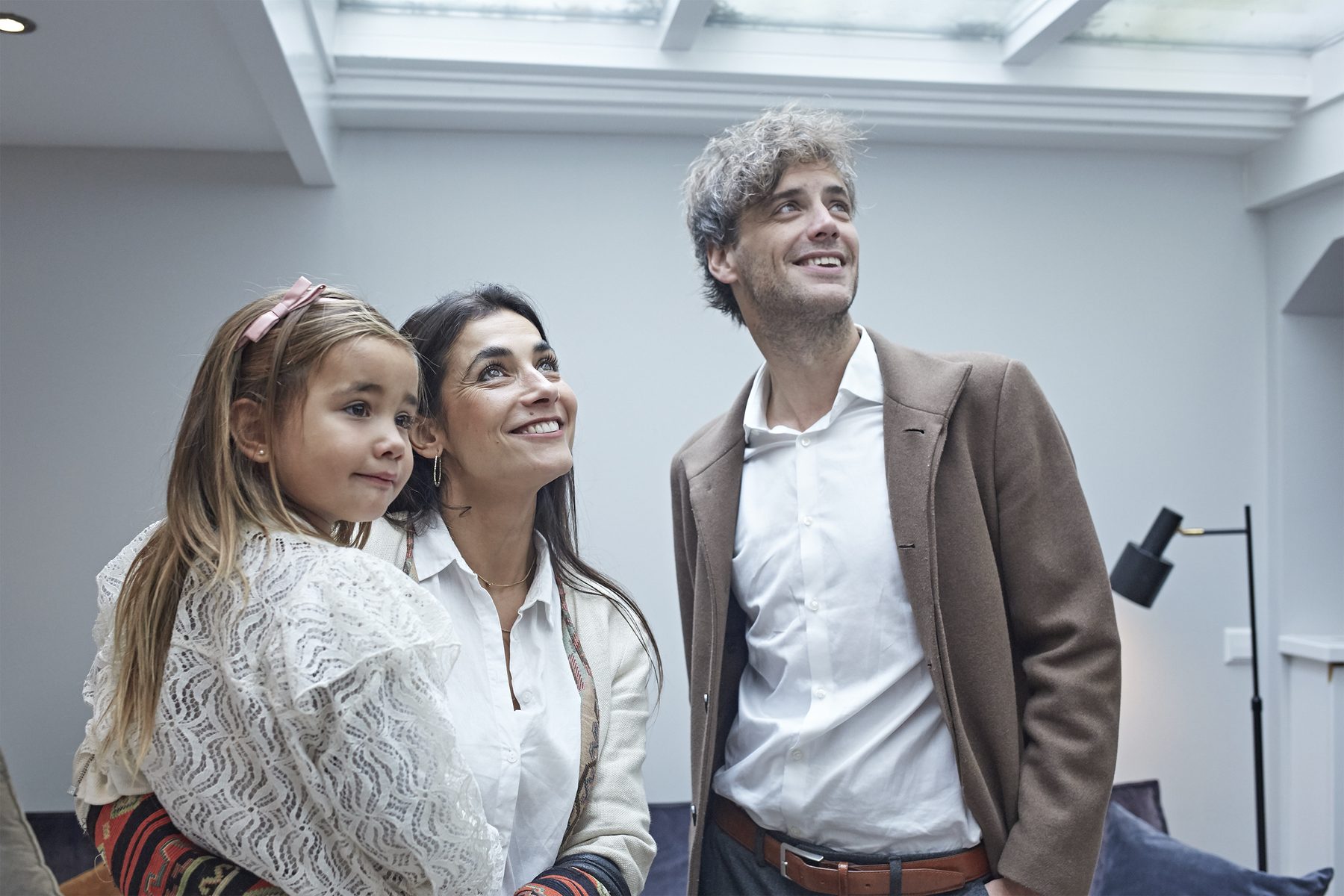 A young family looking round a house under a skylight